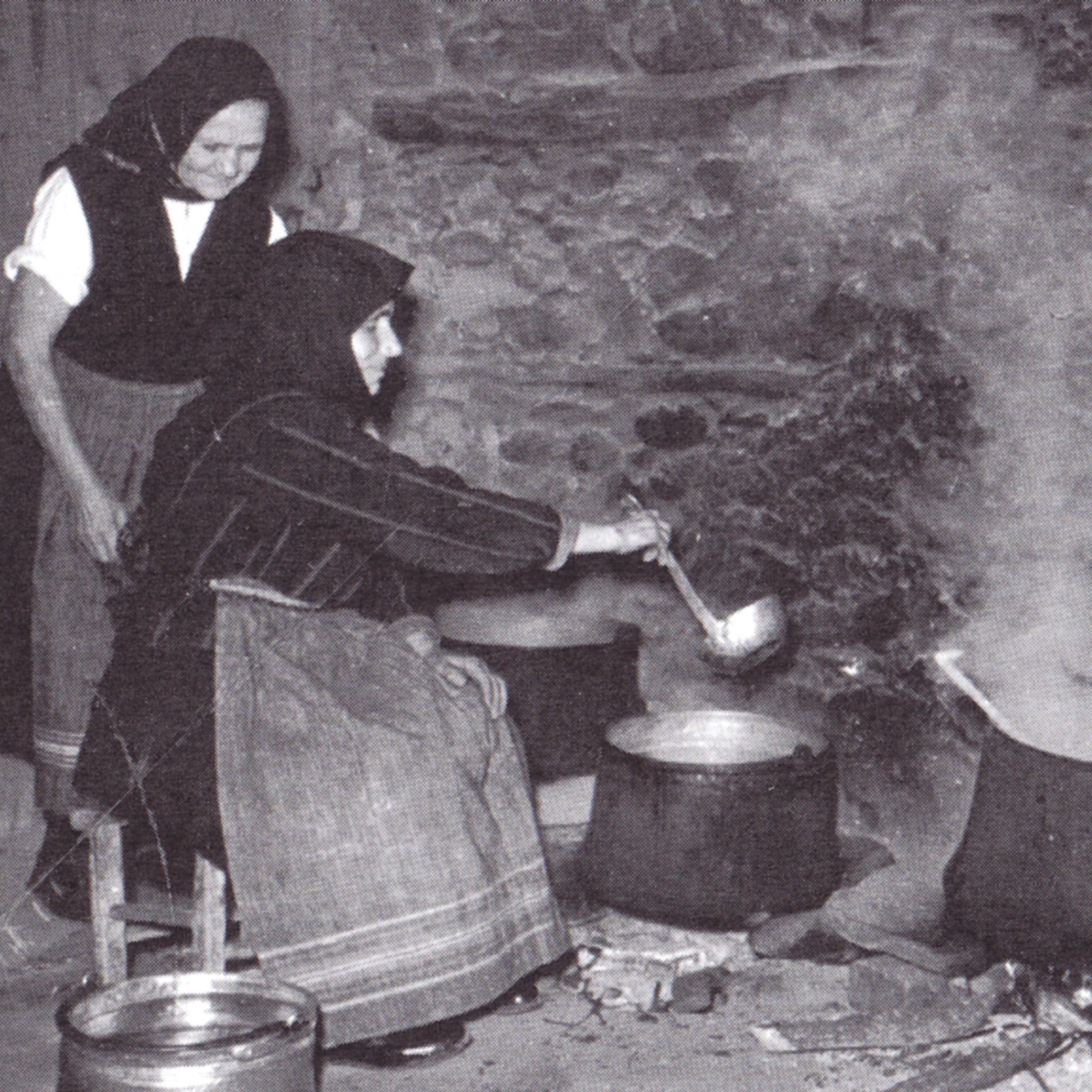 Жени готвят на домашно огнище - черно-бяла снимка.