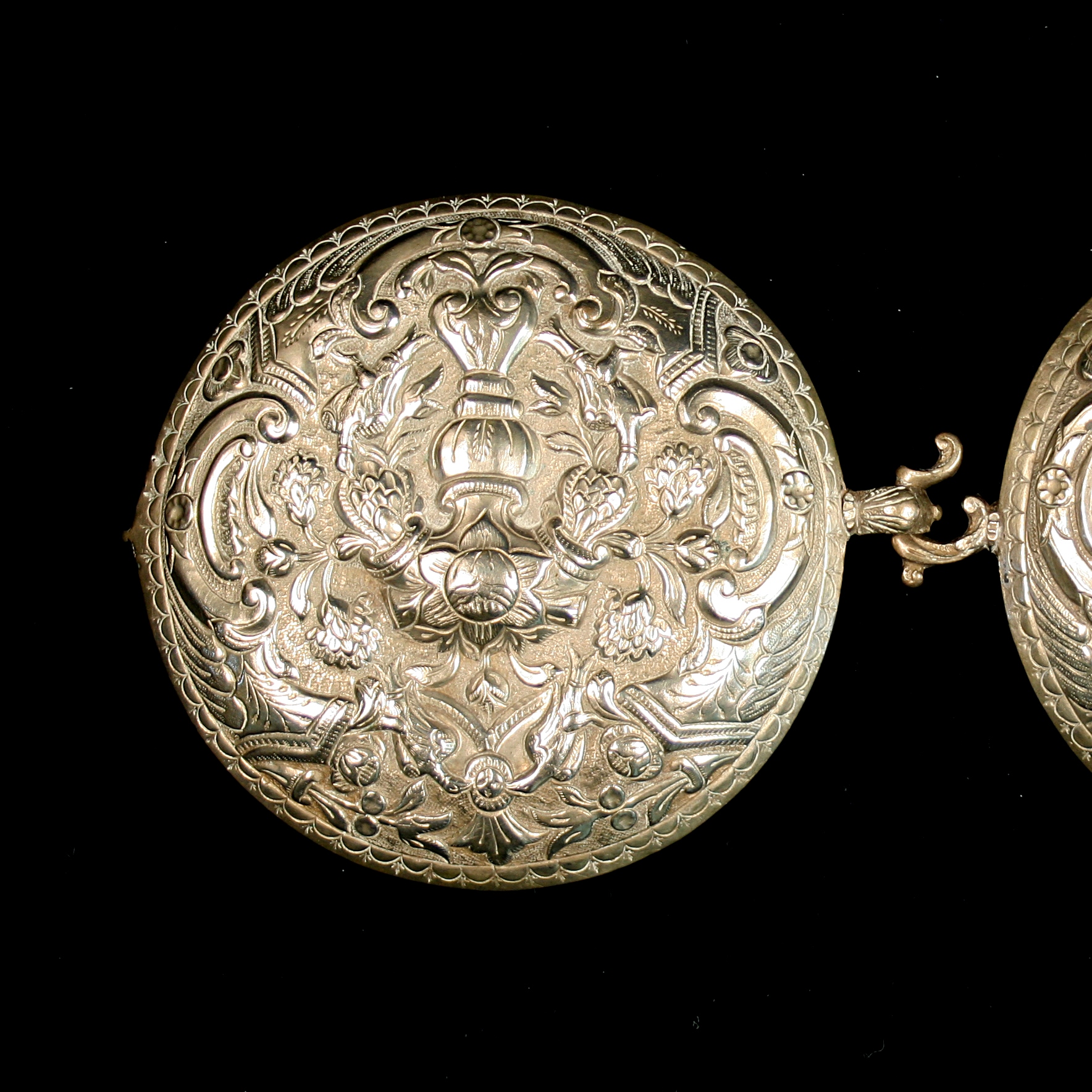 Buckles, round in shape and ornate.